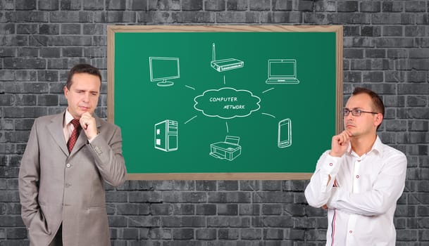 two businessman dreaming and computer network on blackboard