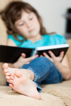 Cute little girl sitting and reading