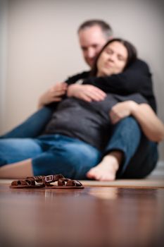 18 weeks pregnant woman sitting on the floor with her husband