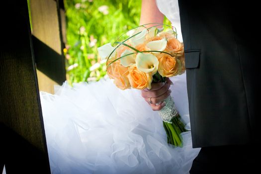 Young married couple - bride holding a wedding bouquet