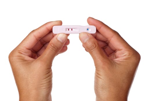 An expectant female holds the result of her pregnancy test upright.