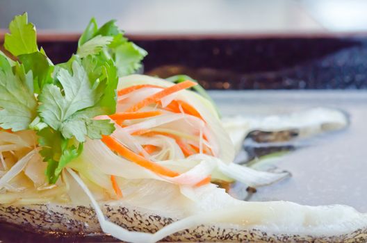 close up steamed white fish fillet with  vegetable on plate
