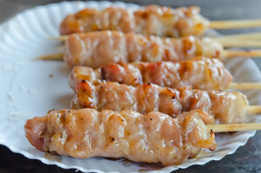 close up grilled pork  marinated  sweet sauce  on white paper plate