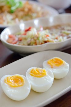 close up slice of boiled eggs on dish .