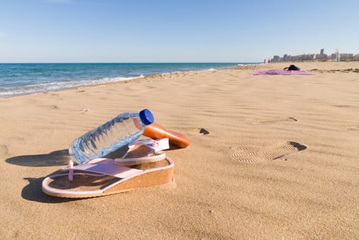 Beach goer objects on sunny sand, summertime