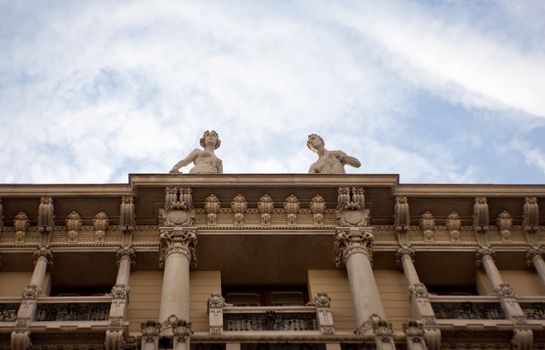 Two statues on building in Trieste, Italy