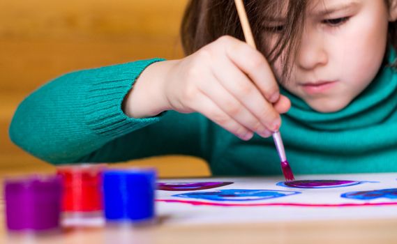 girl draws paints with enthusiasm