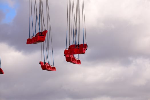Red Carousel seats on cloudy sky