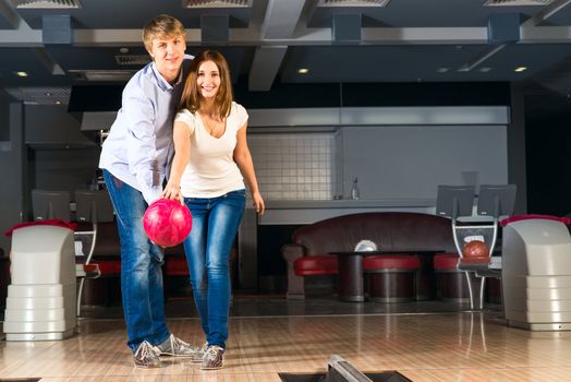 guy hugs her friendgirl, playing together in bowling