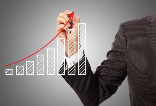 Male hand drawing a graph, grey background