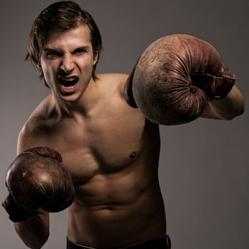 Agressive guy in a boxing gloves ready for a fight