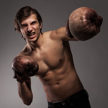 Agressive guy in a boxing gloves ready for a fight