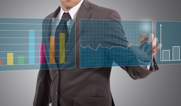 business man touching graphs on screen, grey background