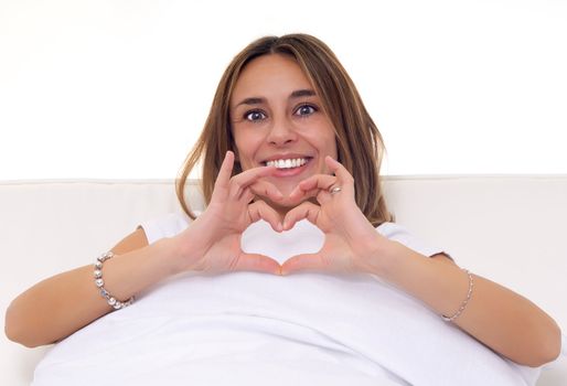 young woman make heart shape with finger while smiling