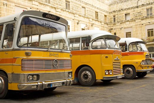 vintage yellow british buses in valetta malta