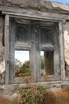 A broken window with no panes in a demolished building in Cotacachi, Ecuador