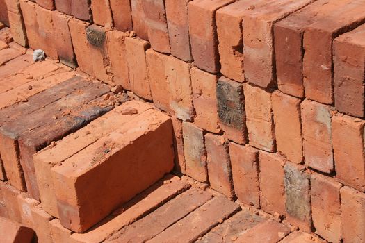 Stacks of handmade adobe bricks are piled in a brickyard in Cotacachi, Ecuador