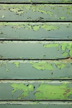 part of weathered old planks of green fencing or boarding