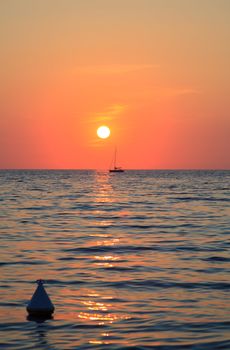 Sunset at sea with a sailboat in Trieste