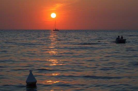Sunset at sea with a sailboat in Trieste
