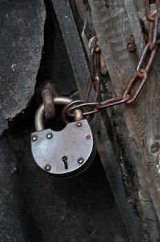 metal padlock on a door with a chain