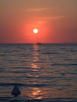 Sunset at sea with a sailboat in Trieste