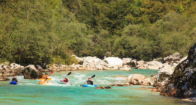KOBARID, SLOVENIA - AUGUST 20: Sport kayakers rowing in the Soca river, August 20, 2012 in Kobarid, Slovenia