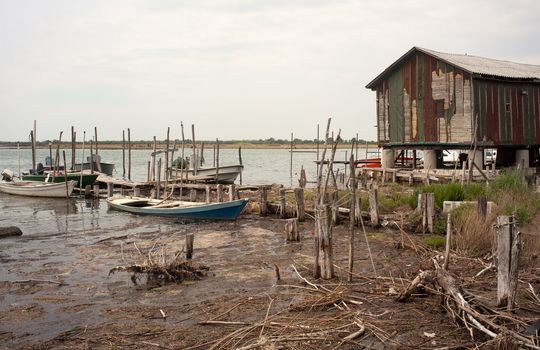 Stilts and old boat in the soca river, Isola della cona