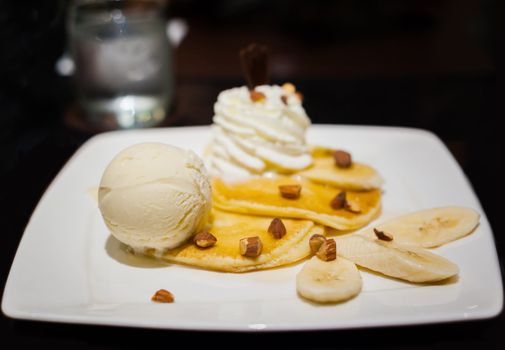 vanilla ice cream on pancake banana split on white dish