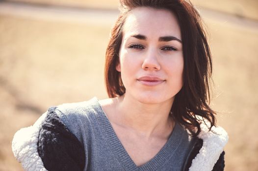 Spring outdoor closeup portrait of young thoughtful woman.