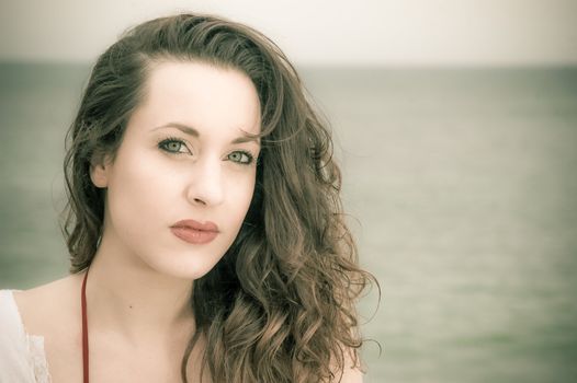 Close up portrait of a beautiful brunette woman at the beach