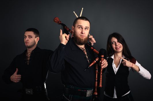 Musical band in scottish costumes with pipe and drums. Studio shot