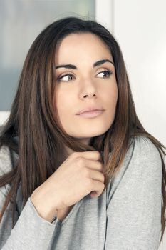 Portrait of beautiful pensive young woman at home