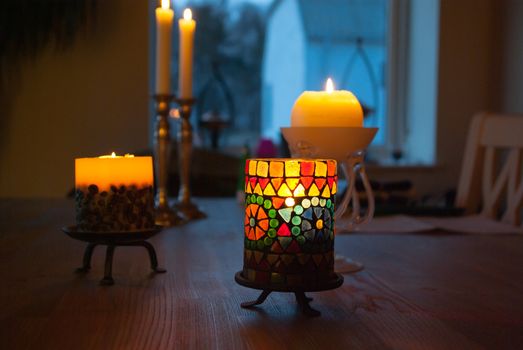 Beautiful colorful glowing burning candle in the darkness