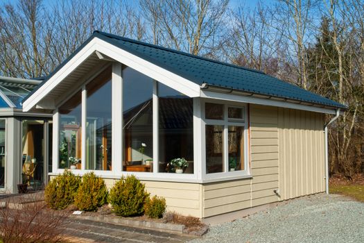 Modern design attractive small wooden home painted in pale yellow color