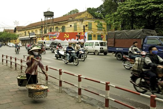 street scene in central hanoi vietnam with traffic and vendor