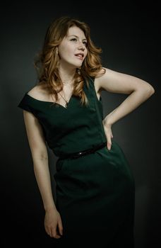 Beutiful young woman  with red hairs in green dress.