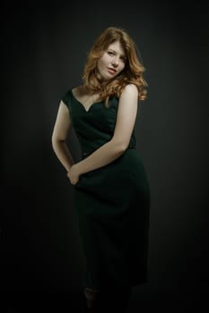 Beutiful young woman  with red hairs in green dress.