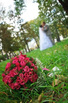 wedding bouquet lying on a green grass on a wedding couple backgrounds.