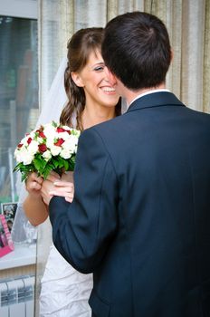 groom gives bride a wedding bouquet and Looks at her