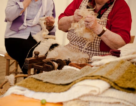 Photo of a elderly woman that spinning wool