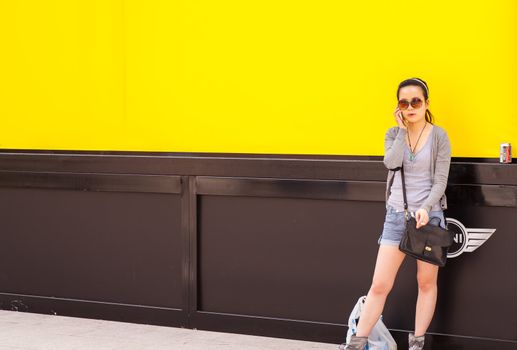 Teenager oriental girl on yellow wall. Fuori salone, Triennale - Mini car exhibition- http://www.triennale.it/en/exhibitions/present/24-triennale-design-week-2012/1011-minicreativeuseofcolouren