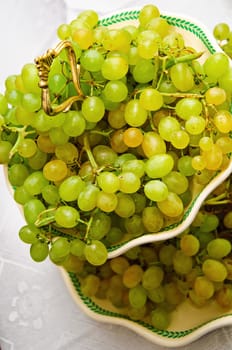 many green bunch of grapes lay on a plate