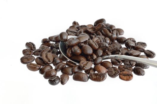 Coffee beans and silver spoon isolated on a white