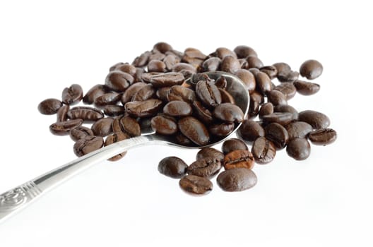 Coffee beans and silver spoon isolated on a white