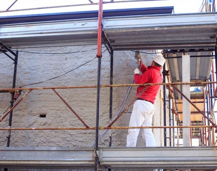 Bricklayer work with cement on scaffold