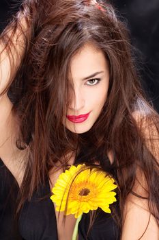 Pretty black dressed woman with long hair and yellow daisy