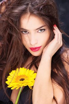 Pretty black dressed woman with long hair and yellow daisy