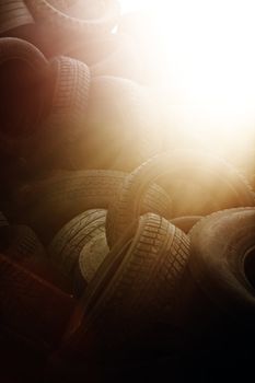Heap of old used tyres in evening sun.