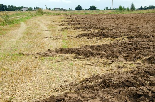 agricultural partly plowed field ground soil in autumn.
